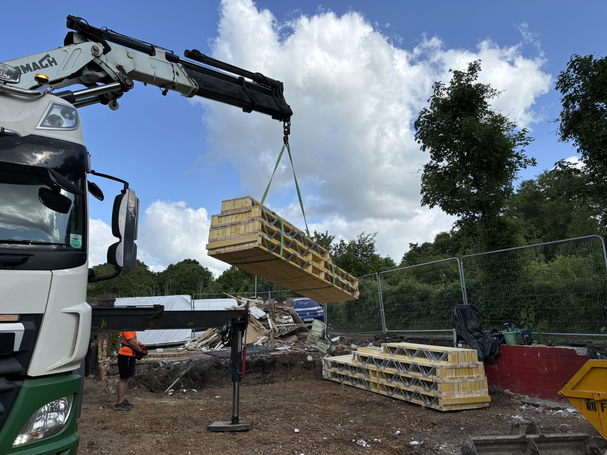 Lorry crane offloading Posi-Joists on a building site